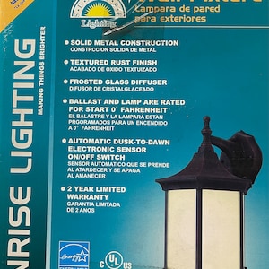 May include: Outdoor wall fixture with a textured rust finish and frosted glass diffuser. Features solid metal construction and an automatic dusk-to-dawn electronic sensor. Includes a 2-year limited warranty. The box reads "Sunrise Lighting".