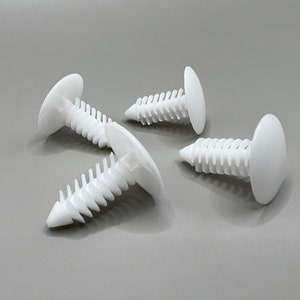 May include: Four white plastic push rivets with a ribbed shaft and a flat, circular head. These fasteners are designed for secure attachment in various applications. The rivets are arranged on a gray surface.