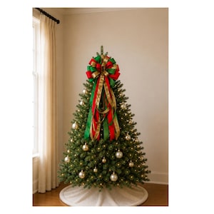 May include: A Christmas tree topper bow featuring layered red, green, and gold ribbons with long, flowing tails. The bow is positioned at the peak of a green artificial Christmas tree decorated with round gold ornaments and warm white string lights.
