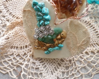 Mosiac stone collage and lace ornament. Turquoise, picture jasper, and green aventurine stones, metal flowers, and coffee-stained lace.
