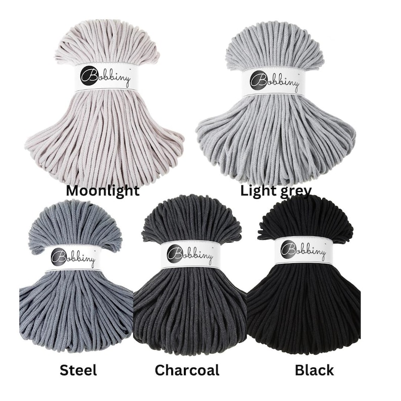 May include: Five hanks of Bobbiny cord arranged in a grid, featuring colors labeled Moonlight, Light grey, Steel, Charcoal, and Black. Each hank is secured with a white paper band displaying the Bobbiny logo in a black circular emblem.