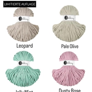 May include: Four skeins of Bobbiny cord in Leopard, Pale Olive, Jelly Mint, and Dusty Rose colors. Each skein is secured with a white paper band featuring the Bobbiny logo. The top left skein includes a black label with the text LIMITIERTE AUFLAGE.
