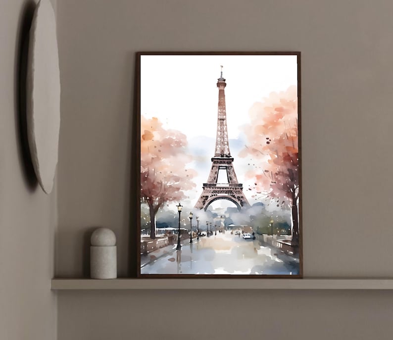 May include: A watercolor painting of the Eiffel Tower in Paris, France. The tower is depicted in the center of the image, with a street lined with trees and lampposts in the foreground. The sky is a light blue, and there are clouds in the distance.