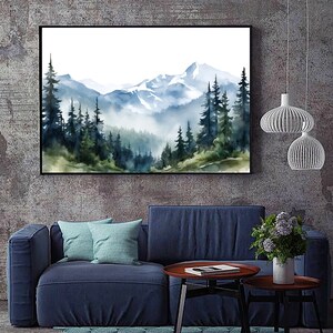 May include: A rectangular wall art print featuring a watercolour landscape of snow-capped mountains and a dense forest of pine trees in shades of blue, green, and white. The artwork is enclosed in a thin black frame and displayed on a textured wall.
