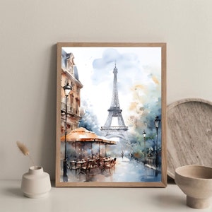 K&ouml;nnte beinhalten: Ein Aquarellbild des Eiffelturms in Paris, Frankreich. Das Bild zeigt eine Stra&szlig;enszene mit einem Caf&eacute; und Passanten. Der Eiffelturm befindet sich im Hintergrund, und der Himmel ist hellblau mit wei&szlig;en Wolken.