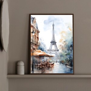 K&ouml;nnte beinhalten: Ein Aquarellgem&auml;lde einer Pariser Stra&szlig;enszene mit dem Eiffelturm im Hintergrund. Das Gem&auml;lde zeigt ein Caf&eacute; mit Tischen und St&uuml;hlen, eine Stra&szlig;enlaterne und B&auml;ume. Der Himmel ist hellblau mit wei&szlig;en Wolken.