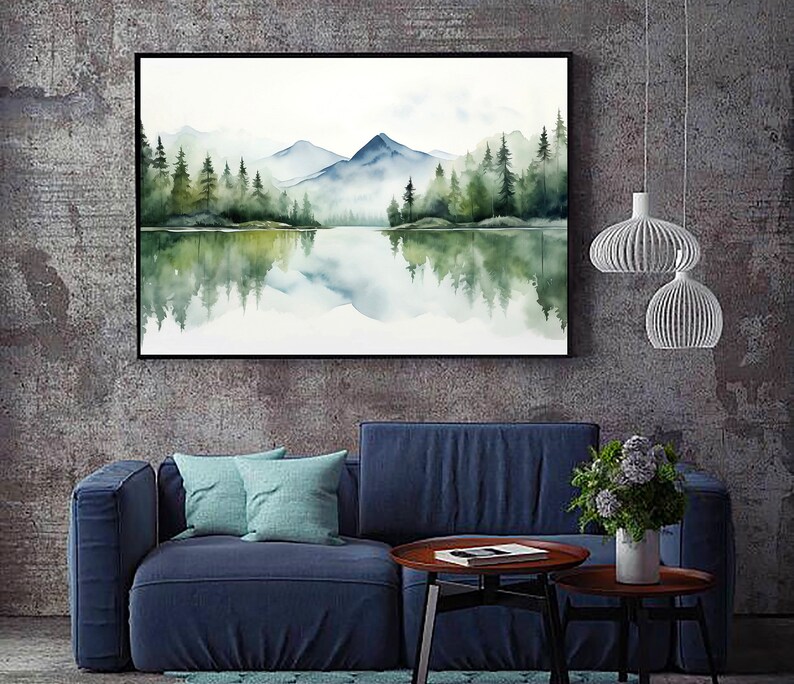 May include: A watercolor painting of a mountain lake scene with a reflection of the trees and mountains in the water. The painting is framed in black and hanging on a gray wall.