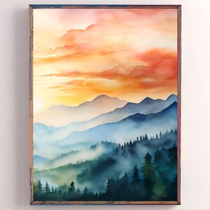 May include: Watercolor landscape art print featuring a mountain range under a vibrant sunset sky. The artwork showcases layers of blue mountains, misty valleys, and a colorful sky with shades of orange and yellow. The print is framed in a rustic wooden frame.