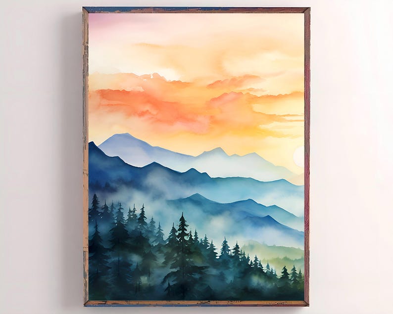 May include: Watercolor painting of a mountain landscape with a sunset. The artwork features layers of blue mountains, a forest of dark green trees, and a vibrant orange and yellow sky. The painting is framed in a rustic wooden frame.