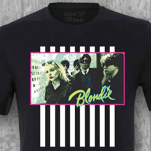 May include: Black t-shirt with a white and black striped design. The design features a photo of the band Blondie with the band name in green and yellow text.