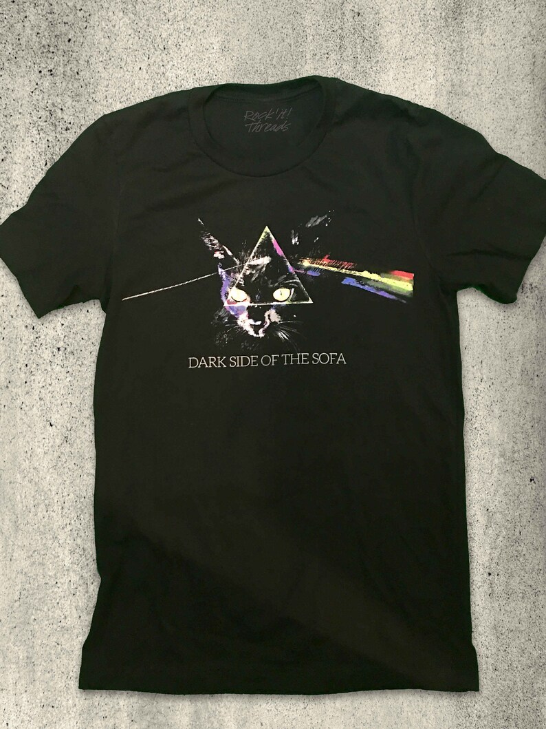 May include: Black t-shirt with a graphic of a cat's face in a triangle with a rainbow beam of light. The text "Dark Side of the Sofa" is printed below the graphic.