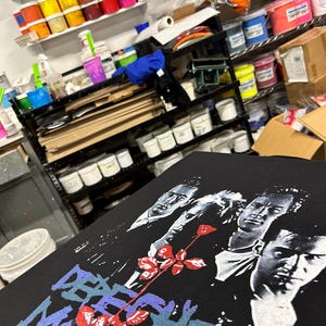Shop view while screen printing the t-shirts of the super group from the 80s, 90s and more. Depeche Mode design including the group, Violator rose and logo.