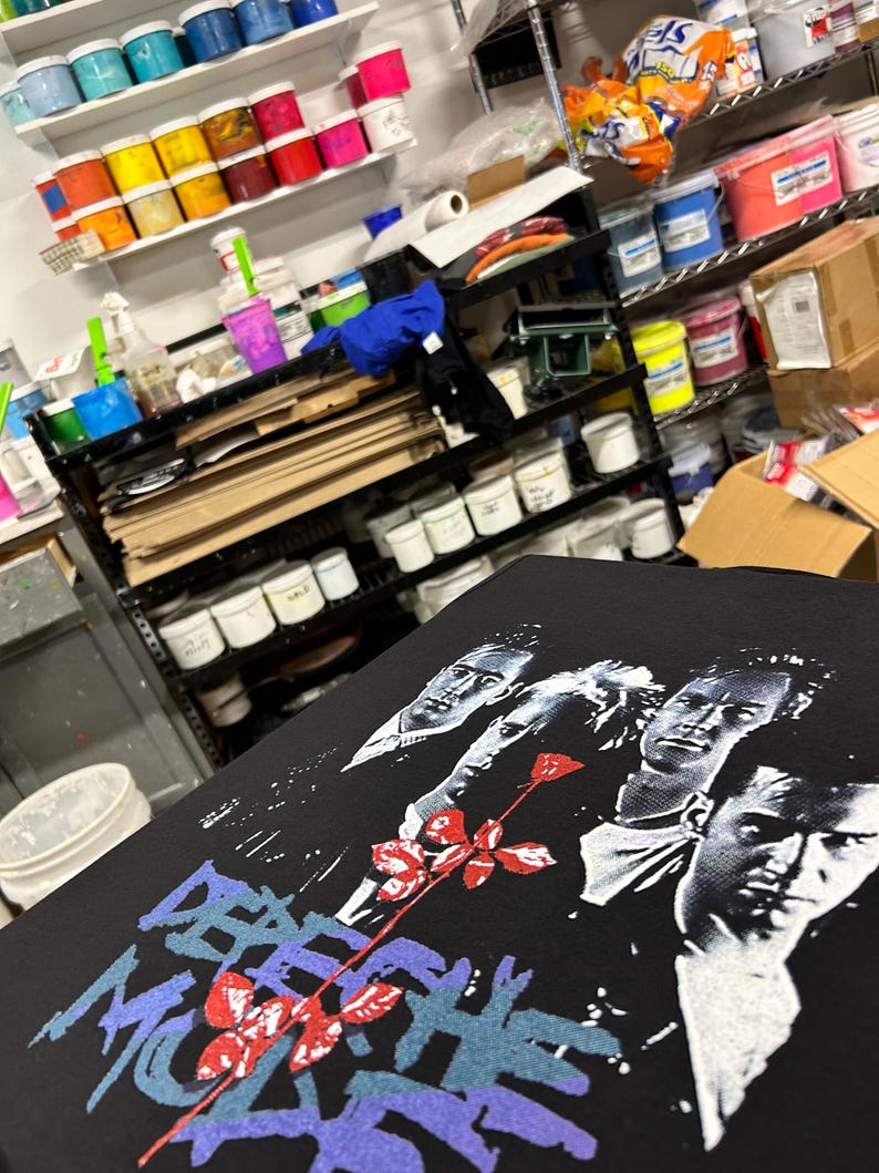 Shop view while screen printing the t-shirts of the super group from the 80s, 90s and more. Depeche Mode design including the group, Violator rose and logo.