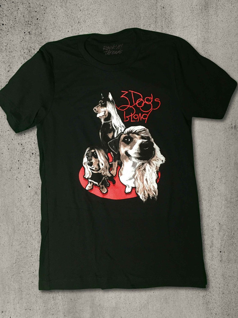 May include: Black t-shirt with a red graphic of three dogs with long hair. The text "3 Dogs Blond" is written in red above the dogs.