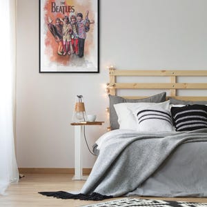 K&ouml;nnte beinhalten: Ein gerahmtes Wandposter mit einer farbenfrohen k&uuml;nstlerischen Illustration der Band The Beatles, die zusammensteht. Das Kunstwerk zeigt die vier Mitglieder in lebendiger Kleidung vor einem warmen, strukturierten orange-gelben Aquarellhintergrund.