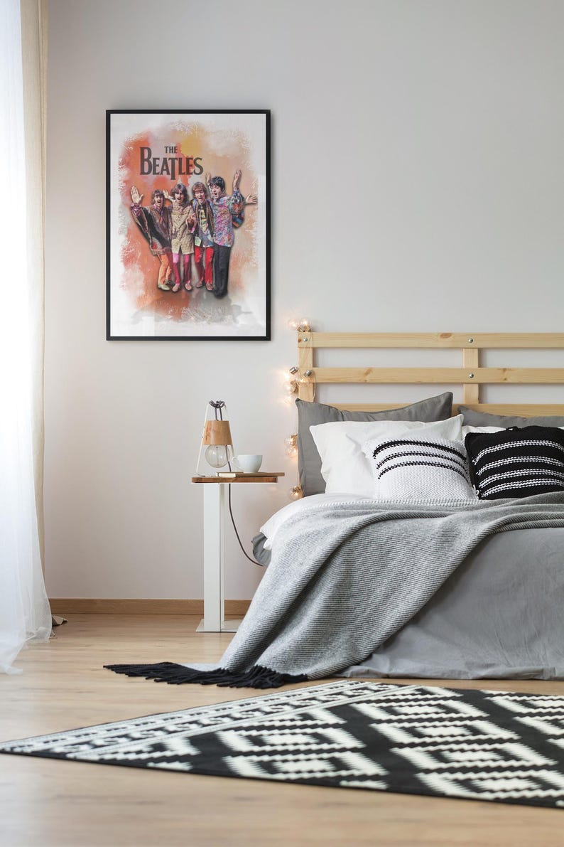 K&ouml;nnte beinhalten: Ein gerahmtes Wandposter mit einer farbenfrohen k&uuml;nstlerischen Illustration der Band The Beatles, die zusammensteht. Das Kunstwerk zeigt die vier Mitglieder in lebendiger Kleidung vor einem warmen, strukturierten orange-gelben Aquarellhintergrund.