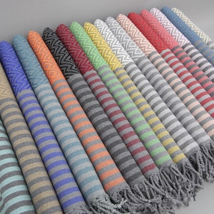 May include: A collection of striped towels with fringe edges in various colors, including teal, beige, gray, blue, orange, yellow, and red.