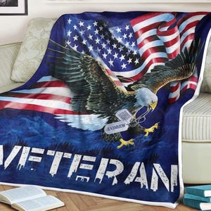 Könnte beinhalten: Eine blaue Fleece-Decke mit einer rot-weiß-blauen amerikanischen Flagge und einem Weißkopfseeadler mit einem Hundemarken, auf dem "ANDREW" steht. Die Decke trägt den Schriftzug "VETERAN" in Weiß.