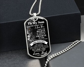 May include: A silver chain necklace with a silver dog tag pendant. The dog tag features a black and white image of a lion and text that reads "To My Son Never Forget That I Love You. I Hope You Believe In Yourself As Much As I Believe In You. When Life Tries To Knock You Down This Old Lion Will Always Have Your Back. I Can't Promise To Be Here For The Rest Of Your Life, But I Can Promise To Love You For The Rest Of Mine. Love, Dad"