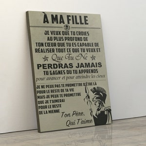 Könnte beinhalten: Ein beigefarbener Leinwanddruck mit schwarzem Text, der "A Ma Fille" lautet und eine Botschaft über das Vertrauen in sich selbst und das niemals Aufgeben. Der Text ist von einem schwarzen Stern und einer schwarzen Illustration eines römischen Soldaten mit einem Speer umgeben.