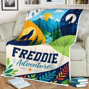 Peut inclure: Une couverture en polaire présentant un paysage graphique avec des montagnes, des sapins et deux silhouettes de loups hurlant à la lune. Le motif inclut le texte "FREDDIE Adventure" en lettres bleu foncé, agrémenté de motifs de feuilles colorées.