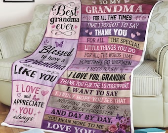 May include: A rectangular throw blanket featuring a purple and pink wood-plank background with printed text that reads To My Grandma, Best Grandma Ever, and other sentimental phrases, decorated with small butterfly and floral illustrations.