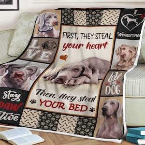 Pode incluir: Uma manta macia e felpuda com um design de raça de cão Weimaraner. A manta tem um design de patchwork com quadrados de diferentes cores e um padrão de pegadas. O texto na manta diz "Primeiro, eles roubam seu coração. Depois, eles roubam sua cama. Amo meu cachorro. Mantenha-se positivo."
