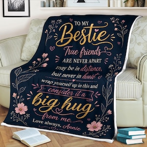May include: A navy blue throw blanket with the text "To My Bestie" in gold script. The blanket features pink floral accents and the message "True friends are never apart, may be in distance, but never in heart."