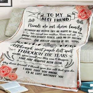 Op de afbeelding: Een witte fleece deken met een bloemenpatroon en zwarte tekst die "To My Best Friend" luidt. De tekst gaat verder met een boodschap over vriendschap en het belang van vrienden die als familie zijn.