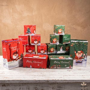 May include: A collection of red and green Christmas-themed gift bags and boxes featuring illustrations of Santa Claus, snowmen, and Christmas trees. The packaging includes text that reads Merry Christmas and the brand name FairySpire.