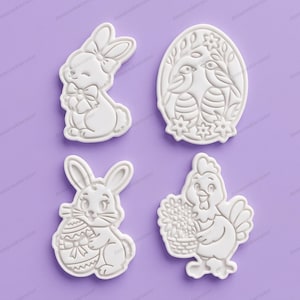 Può includere: Quattro formine per biscotti in plastica bianca a tema pasquale: un coniglietto con fiocco, un uovo con uccelli, un coniglietto con un uovo e una gallina con un cestino di fiori. Le formine sono su sfondo viola.