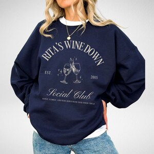 a woman wearing a sweatshirt with a wine glass on it