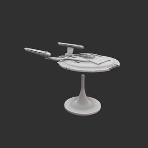 May include: A light grey model starship, with a saucer-shaped primary hull, two warp nacelles, and a secondary hull. The model is mounted on a stand. The overall design is futuristic.