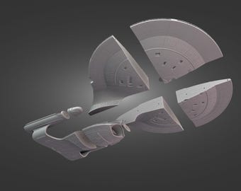 May include: A gray, disassembled model of a spaceship, with the components separated. The model is set against a dark gray background, showcasing the ship's design and structure. The ship's components are in the shape of a saucer, a cylindrical body, and two nacelles.