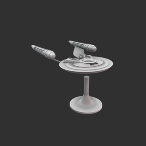 May include: A light grey model of a spaceship, featuring a saucer-shaped hull, two warp nacelles, and a cylindrical support stand. The model is set against a dark grey background.
