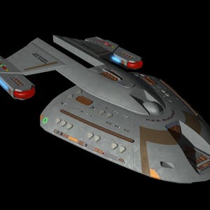 May include: A gray and white spaceship with a brown and gold design. The ship has a large, round main body and two smaller, wing-like sections. The ship is labeled "U.S.S. RUDDER" on the side.