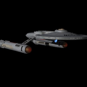 May include: A gray spaceship with the text "NCC-1701" on the saucer section and the nacelles. The ship has a saucer-shaped primary hull, a secondary hull, and two warp nacelles. The nacelles have orange and red glowing details. The background is black.