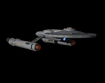 Può includere: Un'astronave grigia con la scritta "NCC-1701" sulla sezione a forma di disco e sulle gondole. L'astronave ha uno scafo principale a forma di disco, uno scafo secondario e due gondole di curvatura. Le gondole hanno dettagli luminosi arancioni e rossi. Lo sfondo è nero.