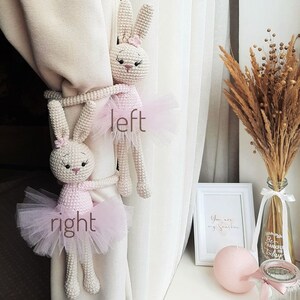 Puede incluir: Dos lazos de cortina de conejito de crochet en rosa y blanco con faldas de tul. El conejito de la izquierda est&aacute; etiquetado como "izquierda" y el conejito de la derecha est&aacute; etiquetado como "derecha".