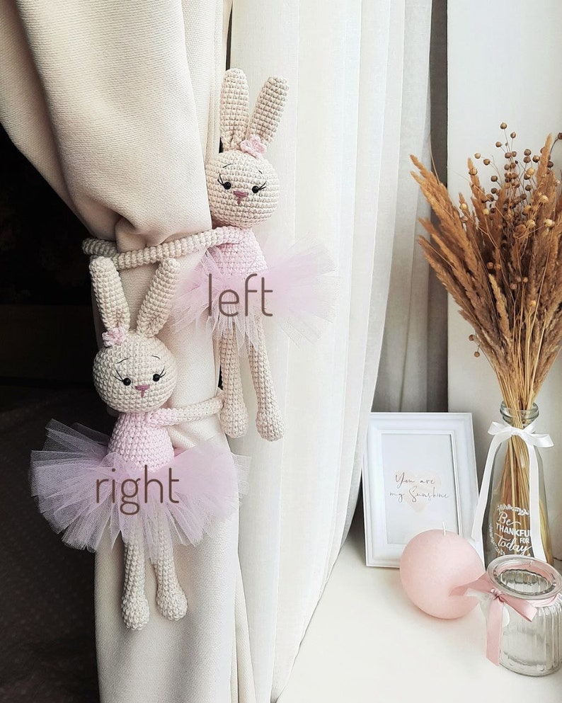 Puede incluir: Dos lazos de cortina de conejito de crochet en rosa y blanco con faldas de tul. El conejito de la izquierda est&aacute; etiquetado como "izquierda" y el conejito de la derecha est&aacute; etiquetado como "derecha".