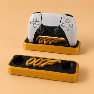 May include: A white and black game controller resting on a gold and black rectangular stand featuring the text 007. A matching gold and black rectangular stand with the text 007 and two circular cutouts is positioned in the foreground.