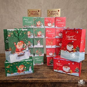 May include: A collection of green and red gift bags and boxes featuring illustrations of Santa Claus, reindeer, and Christmas trees. Each item is printed with the text Merry Christmas. The set includes various square boxes and two large gift bags.