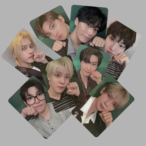May include: A collection of seven rectangular photo cards featuring portraits of young individuals with various hair colours and styles. Each person is posed with a hand near their face, mimicking a cat-like gesture. The cards are arranged in a circular pattern.