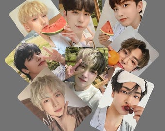 May include: A collection of eight photo cards featuring young people. Some cards show the subjects holding watermelon slices, an orange, and cherries. The cards have a diamond shape and are arranged on a gray background.