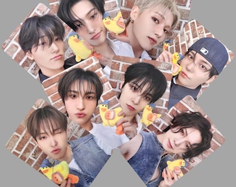 May include: A collection of seven photo cards featuring different individuals. Each card displays a person holding a yellow duck toy against a brick wall background. The individuals have various hairstyles and expressions.