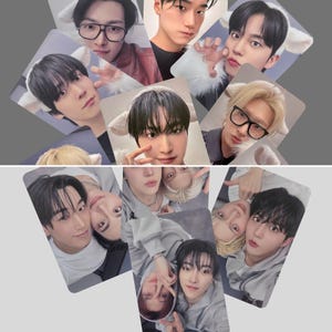 May include: A collection of rectangular photo cards featuring various young men. Some cards show individuals wearing cat ear headbands, while others feature pairs of men. The cards are arranged against a gray background.