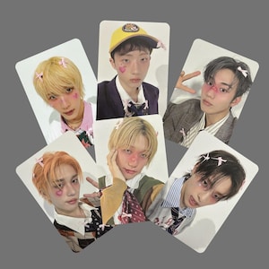 May include: A collection of six rectangular photo cards featuring young people with pink blush and bow accents. The subjects are wearing various outfits, including blazers, striped shirts, and a yellow baseball cap. Each card has a white border.