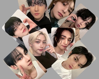 May include: A collection of eight photo cards featuring different members of a K-pop boy band. Each card features a close-up portrait of a different member with a variety of hairstyles and expressions.