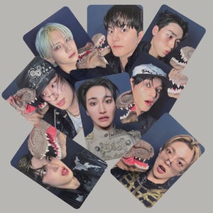 Puede incluir: Colección de siete tarjetas fotográficas con jóvenes posando con una marioneta de dinosaurio. Las tarjetas están dispuestas en un patrón disperso sobre un fondo azul oscuro. Las personas visten varios atuendos y accesorios.