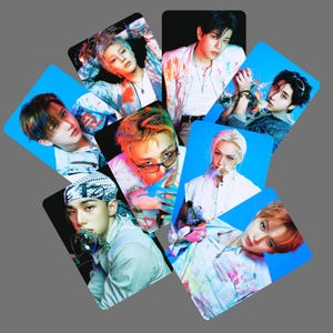 May include: A collection of seven rectangular photo cards featuring portraits of young individuals with diverse hair colors and styles, wearing light-colored clothing with paint splatters, set against vibrant blue and black backgrounds.